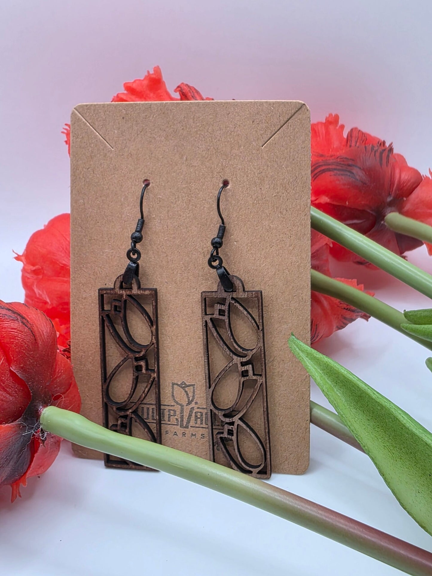Intricate Framed Tulip Earrings with tulips in the background from Tulip Valley Farms