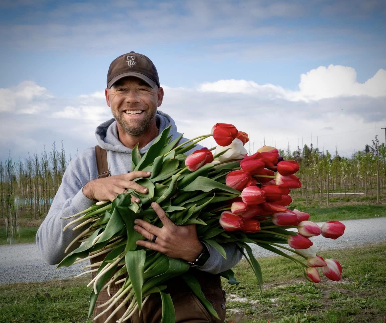 Andrew holding a bundle of red tulips at Tulip Valley Farms